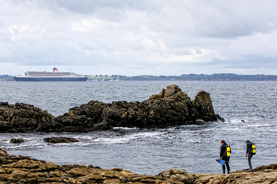 The Queen Mary 2 passing Groix Island, on her way to Saint Nazaire for the start of the centennial Transat "The Bridge 2017", a historic transatlantic race between her and a fleet of giant trimarans.